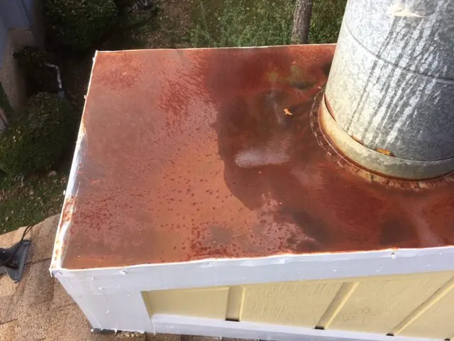 Rusted galvanized chase top on a prefab chimney